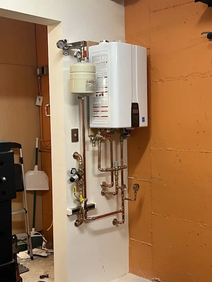 Plumbing technician inspecting water heater connections in Conklin